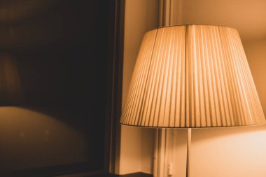 Sıcak ışık ve penceresinde yansıma olan zemin lambası