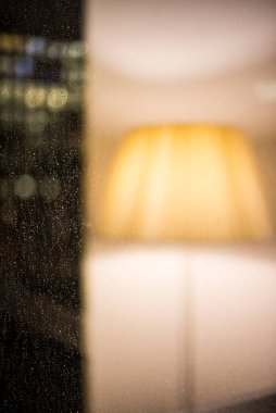 Sıcak ışık ve penceresinde yansıma olan zemin lambası