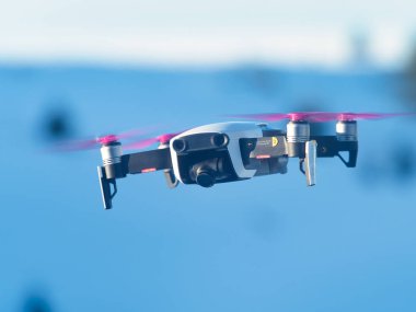 Mavi gökyüzünün arkasında ve çekim sırasında kameralı bir dron.