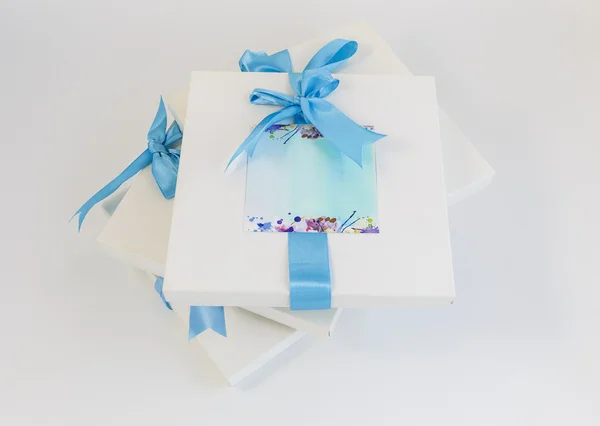 Beyaz zemin üzerinde mavi kurdele ile hediye kutuları — Stok fotoğraf