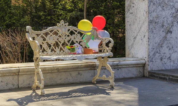 Balloons tied to an old bench and boxes with gifts — Stock Photo, Image