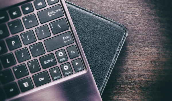 Die Tastatur und das Tablet in einem Lederetui auf einem hölzernen Surfac — Stockfoto