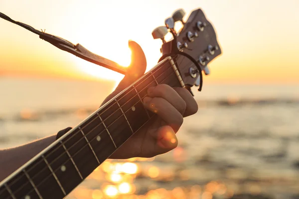 Young guy playing a guitar at sunset(Soft Focus) — Stock Photo, Image