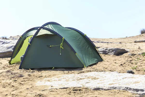 Tourist tent disintegrated on the rocky shore — Stock Photo, Image