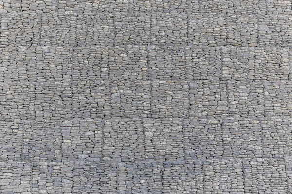 The wall of river stones packed in a metal grid — Stock Photo, Image