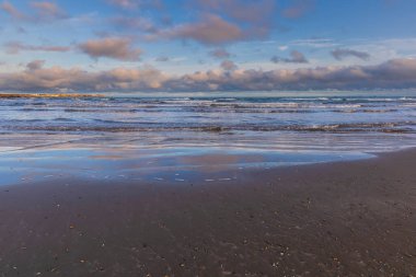 Güneşli bir günde kumsalda dalgalar
