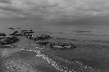Denizin sığ sularından sonra kıyıda kaya parçaları vardı.