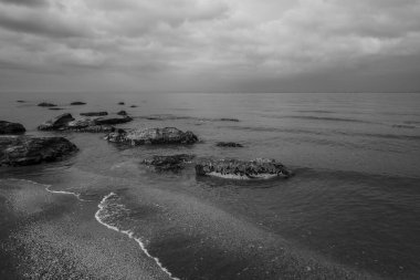 Denizin sığ sularından sonra kıyıda kaya parçaları vardı.