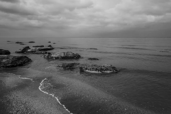 Denizin sığ sularından sonra kıyıda kaya parçaları vardı.