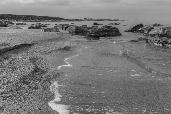 Denizin sığ sularından sonra kıyıda kaya parçaları vardı.