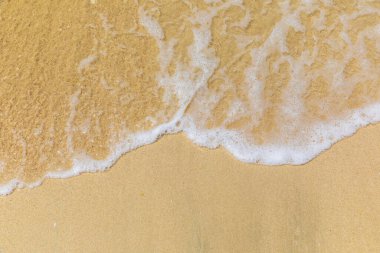 Dalgalar kumlu kıyıya vurur