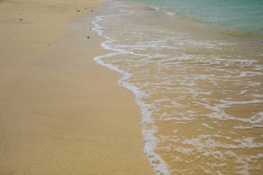 Dalgalar kumlu kıyıya vurur