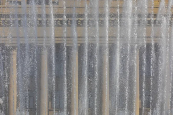 柱付きの建物の背景に噴水ジェット — ストック写真