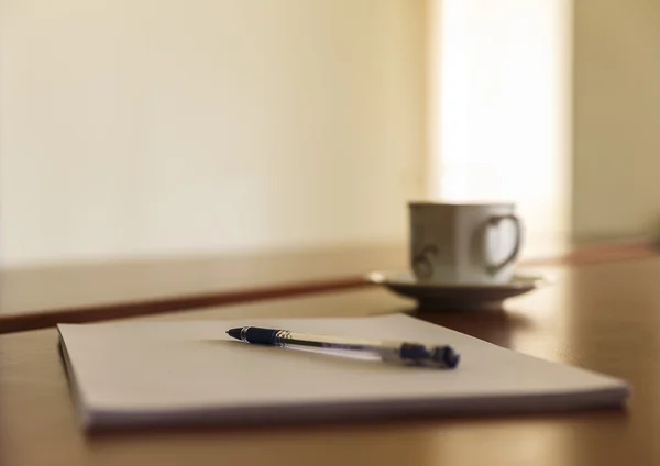Tasse und ein Stapel Papiere auf seinem Schreibtisch — Stockfoto