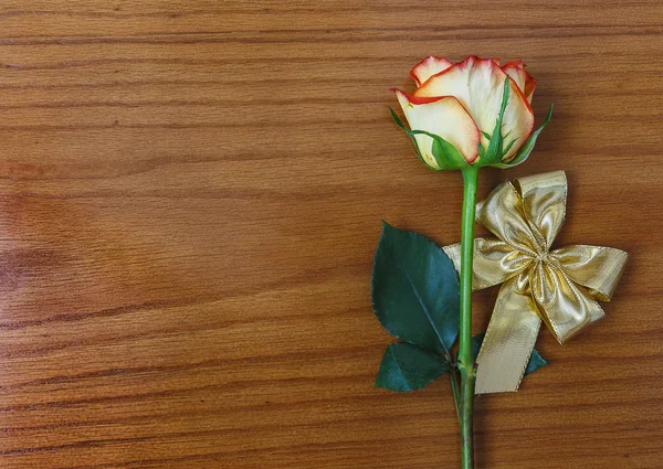 Rose and gold decorative bow on the wooden background — Stock Photo, Image