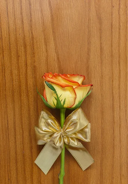 Rose and gold decorative bow on the wooden background — Stock Photo, Image