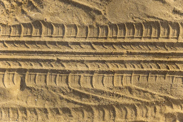 Spår av hjulet trampa på en sandstrand — Stockfoto