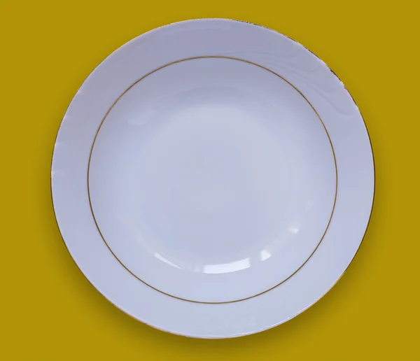 Tom vit platta på ett gult bord. Visa från ovan — Stockfoto
