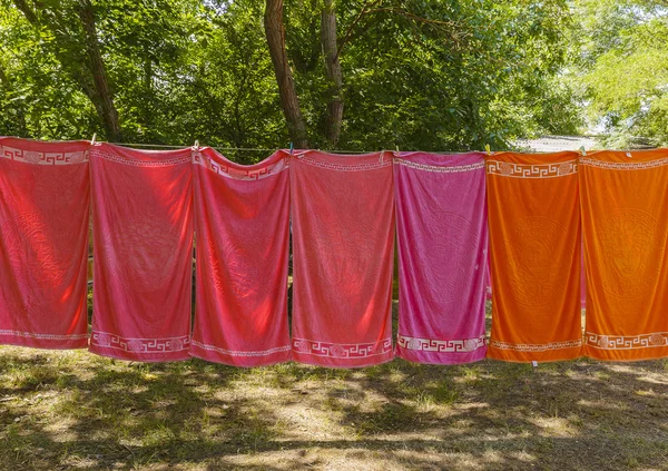 Bunte Handtücher hängen an einem Seil im Wald — Stockfoto