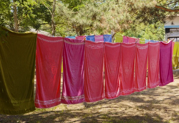Bunte Handtücher hängen an einem Seil im Wald — Stockfoto