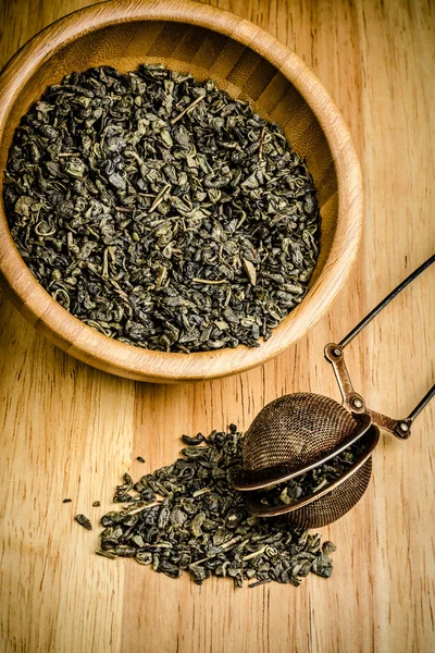 Green tea, dried leaves with filter, on wooden backgroun — Stock Photo, Image