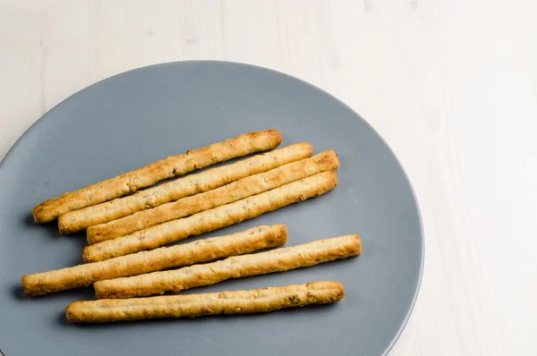 Rustik breadsticks bir tabak üzerinde ahşap masa, yakın çekim, arka plan