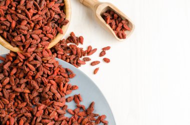 Goji berry bir tabak içinde kaşıkla, closeup arka plan kurutulmuş