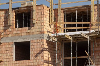 İskele ve açık koyları gösteren alt cephe, üst üste yığılmış engeller, metal aksesuarlar ve güvenlik korkulukları, cesur dokular, kapanış perspektifi, ticari işler ve zeminde sahnelenen malzemeler