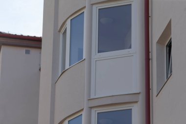 Kuru giysiler ve sıcak gölgeler sergilenen bir balkon, sıcak çevre gölgeleriyle birlikte balkonda asılı duran bir çamaşırhane, asılı giysiler ve yumuşak sıcak gölgeler oluşturan bir balkon.