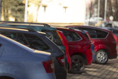 Güneşin altında sıkıca park edilmiş araçlar, düzenli bir şekilde dizilmiş ortak arabalar, parlak güneş ışığı altında yakın park edilmiş kompakt araçlar, sıkıca park edilmiş küçük arabaların sıralanması.