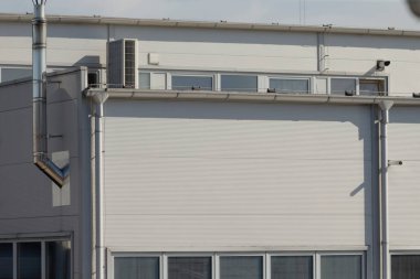 Endüstriyel açıkta kalan borular, beyaz sanayi duvarı teşhir edilen havalandırma boruları ve montajlar, kullanışlı endüstriyel estetik, açıkta kalan havalandırma sistemleri ve yararlı mimari.