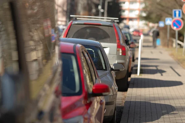 Sabah kaldırım boyunca sıra sıra park edilmiş arabalar, camlarda yansımalar, çeşitli renkler, bokeh arka plan, kaldırım ve park halindeki dizilimler banliyö rutinini ve şehir atmosferini çağrıştırıyor.