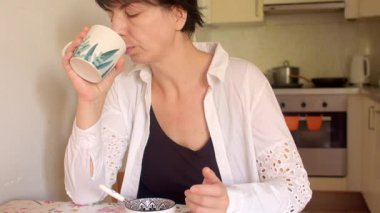 Çay içen bir kadın, sakin bir anın tadını çıkaran sakin bir kadın huzurlu bir ortamda içkinin tadını çıkaran bir kadın.