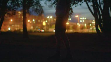 Gizemli bir video, karanlık bir parkta yalnız bir figüre dönüşen ve yalnızlığı ve tefekküre dalmayı çağrıştıran bir şehir manzarası gösteriyor.