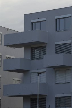 Huzurlu balkon sahnesi, basit tasarım ve huzurlu sabah atmosferiyle sakin yerleşim alanı, yetersiz geometrik yapıları olan sessiz banliyö sokakları ve hafif sabah aydınlatması.