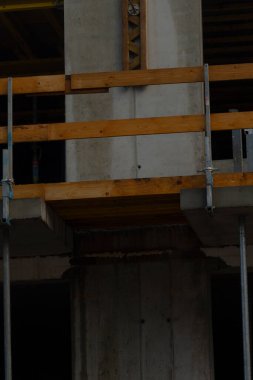 Kentsel yenileme sahnesi, canlı köşe aksanları ve iskeleler içeren inşaat halindeki cephe, tamamlanmamış dış duvar parlak aksanlar ve yenileme atmosferi.