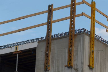 İnşaat alanı taslağı, güvenlik özellikleri olan güçlendirilmiş levha, karanlık gökyüzü altında vurgulanmış endüstriyel çerçeve, korunmasız takviye ve koruyucu bariyerlerle sergilenen yapısal aşama