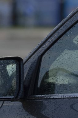 yakın perspektifte çerçevelenmiş ıslak ayna ve pencere yansıtıcı damlacıklar, banliyö görüşü, sessiz renkler