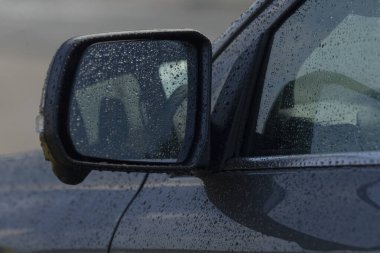 yağmur lekeli yan ayna ve iç yansıtıcı iç şekillere sahip kapı yakın plan, banliyö bağlamında, yumuşak ışık