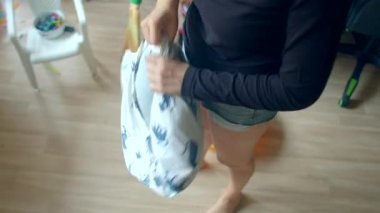 Kadın yastığı kovanın üzerinde kabartıyor ve yerleri süpürüyor, hafifçe sallanıyor ve toz salınıyor, şortlar, yumuşak yastıklar