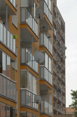 Şehir ortamında balkonların ve uydu antenlerinin olduğu modern apartman manzarası. Gayrimenkul ve mimari tasarımlar için ideal.