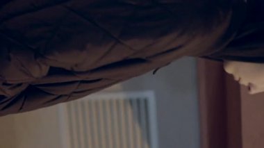 Örtülü ceketli beyaz adam loş mağazanın önünde bekliyor, sokak lambasının altında yan profil, kapüşonlu, havalı sinema tonları, sahte trafik ışıkları, derin derin düşüncelere dalmış duruş yalnızlık ve kentsel duruşu gösteriyor.