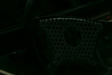 Kapalı direksiyon şebeke ayrıntıları, aşınmış deri, krom kaplama ve dokunmatik ızgara ile iç döküntü klasik araba iç mekanı, alacakaranlıkta şehir sokağına park edilmiş sürücü duraksamasını öneriyor.