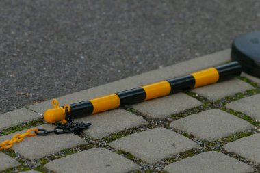 Çizgili direk detayı, zincirleme bağlı şehir direği kaldırımda çizgili sırık ve zincir halkanın yakın çekimi, şehrin kaldırım kenarındaki metal direğin ve zincirin yatay görüntüsü.