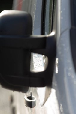 Ayna menteşesi ve hasarı yakından inceleyin. Tamirci, yıpranmış ayna menteşesi ve gevşek halkayı yakından inceler.