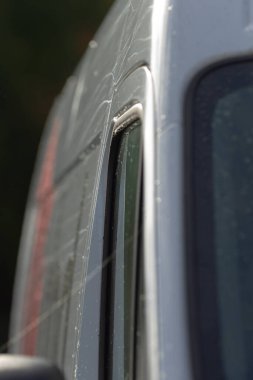 Servis minibüsü ve araç yan camında grafikleri, damgalama ve yıpranmış çıkartmaları olan servis aracı, yan camlarda servis minibüsü markaları ve yıpranmış çıkartmaları gösteren araç grafikleri