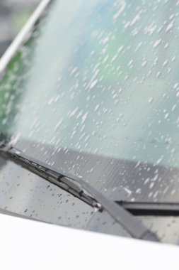 Sığ odak, cam eğriliğini, ön cam yüzeyindeki su boncuklarını vurgulayan yüksek açılı görüntüyü, su damlacıklarını yakalayan detaylı kurşunu ve yumuşak çevre yansıtmalı cam eğriliğini vurgular.