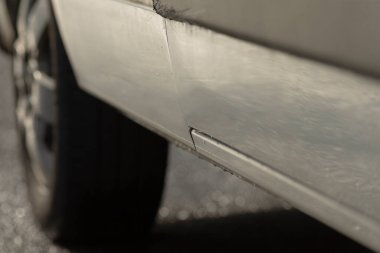 Minibüs paneli aralığı pas ve göçüğü gösteriyor. Mekanik bölmedeki çarpışma onarım senaryosu. Dikiş boyunca perçinlenmiş perçinler, dökülmüş boya ve aşınma.