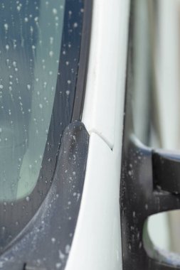 sabun ve köpüklü yan ayna, apillar süslemesi, dikiş ve mühür üzerine ayrıntılı odaklanma, boya damlacıkları ve yansıtıcı camlar bulanık arkaplanı gösteriyor, dikkatli durulama parlak bitirici