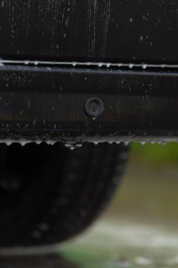 Su yansıması, araba tamponunun kapanışı, su yansımaları ve parlak bitiş, ışıldayan su yansımaları ve detaylı sensör özelliklerine sahip araç tamponunun ayrıntılı görüntüsü.